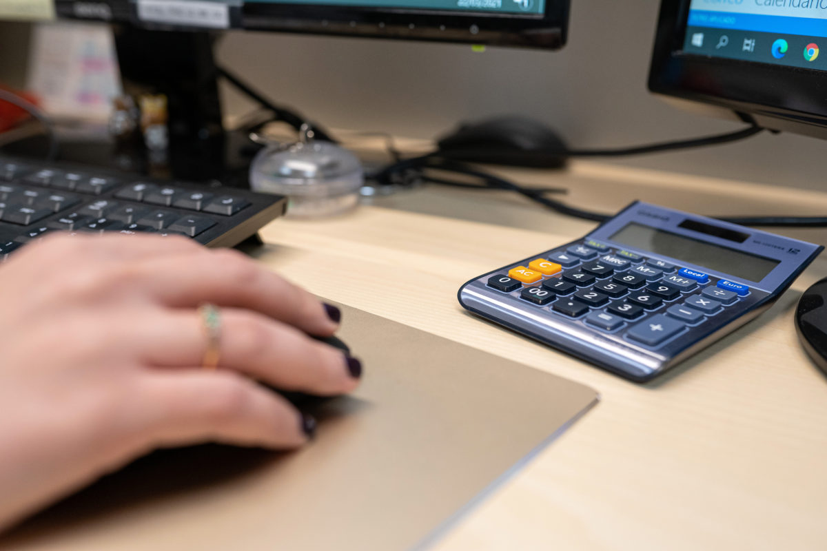 mano con un ratón de ordenador y calculadora de escritorio