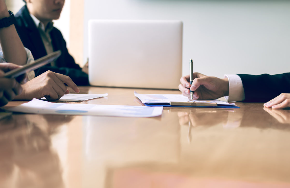 manos firmando recursos sobre una mesa